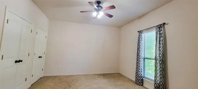 a view of a livingroom with a ceiling fan and window