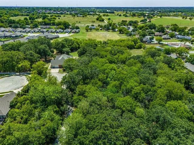 an aerial view of a house with a yard and lake view