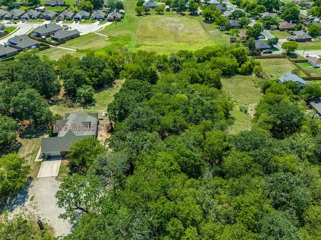 an aerial view of residential houses with outdoor space and street view