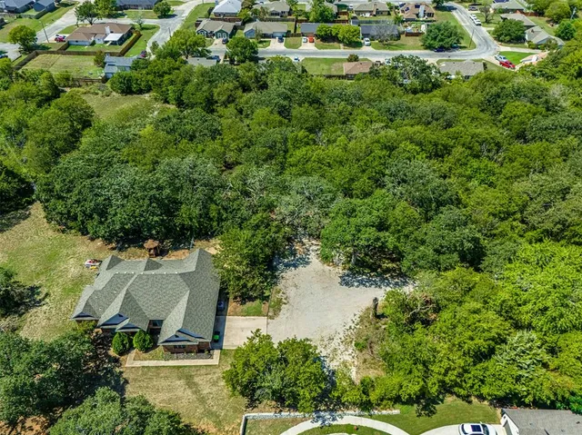 an aerial view of residential house with outdoor space and trees around
