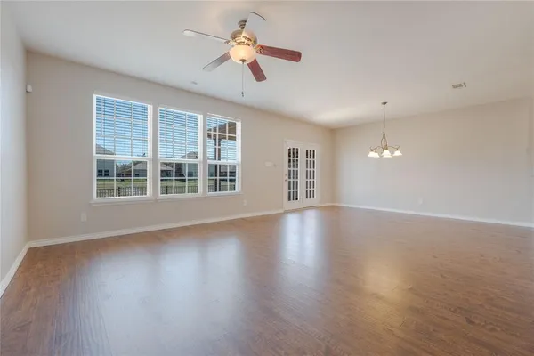 a view of a livingroom with wooden floor and a ceiling fan