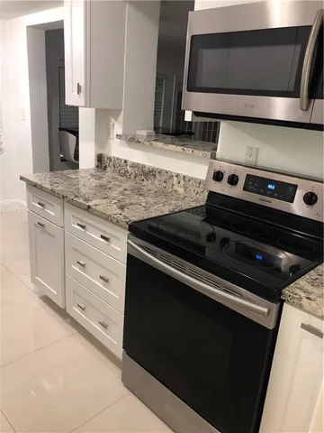 a kitchen with granite countertop a stove and a sink
