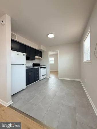 a kitchen with a refrigerator and a stove top oven