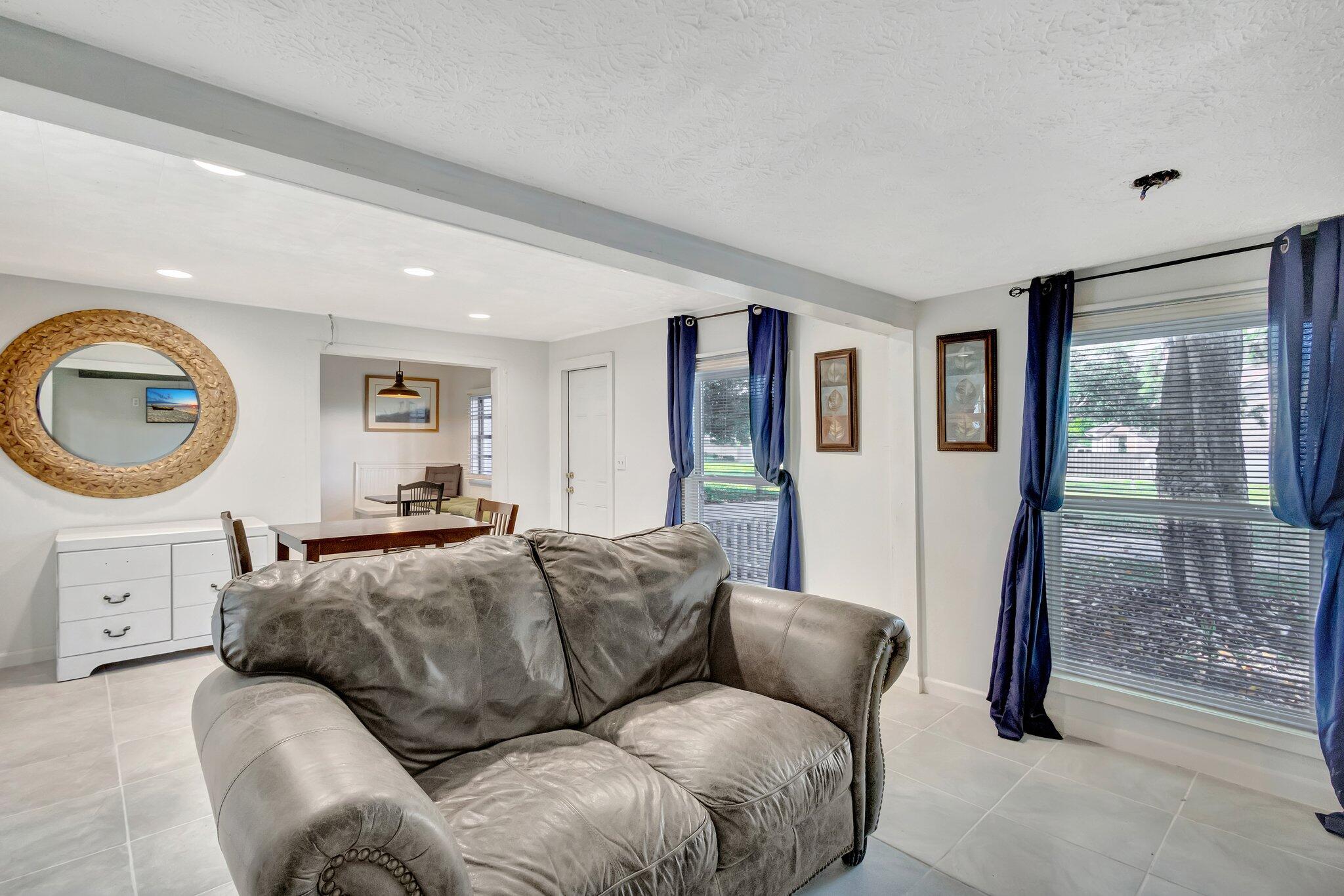 3539 Edwards Road Fort Pierce, FL 34981 - Photo 2 of 39 a living room with furniture a mirror and a large window