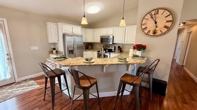 a dining room with wooden floor a clock and a table