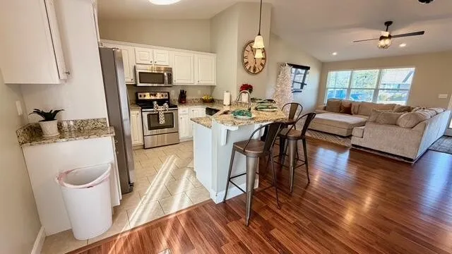 a living room with furniture a wooden floor and a large window