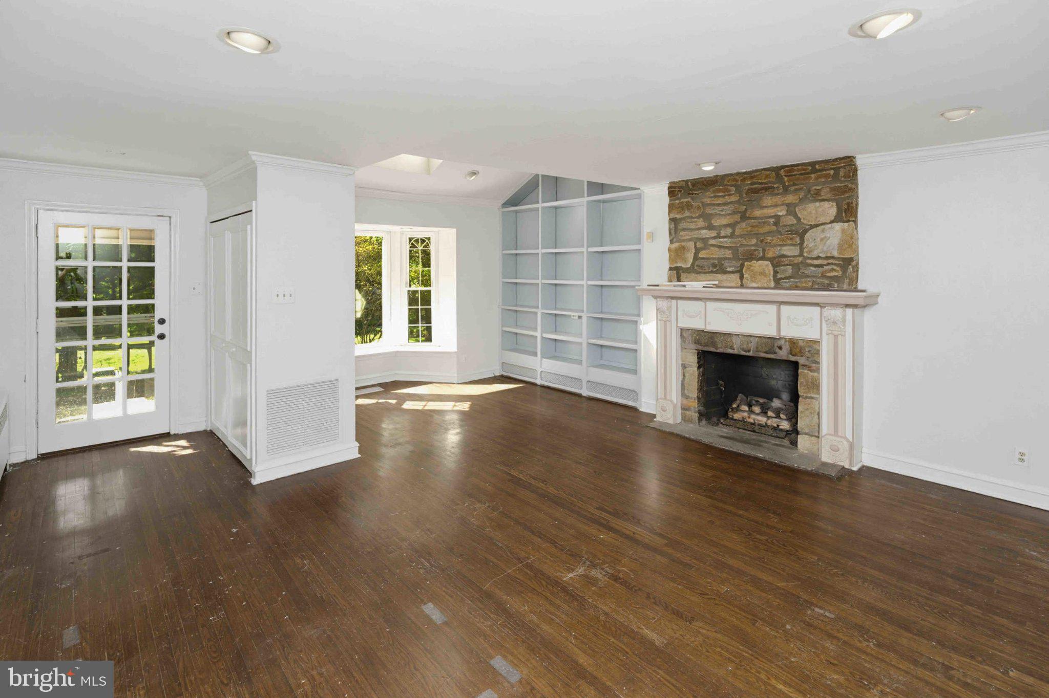 1268 Rydal Road Jenkintown, PA 19046 - Photo 18 of 31 an empty room with wooden floor fireplace and windows