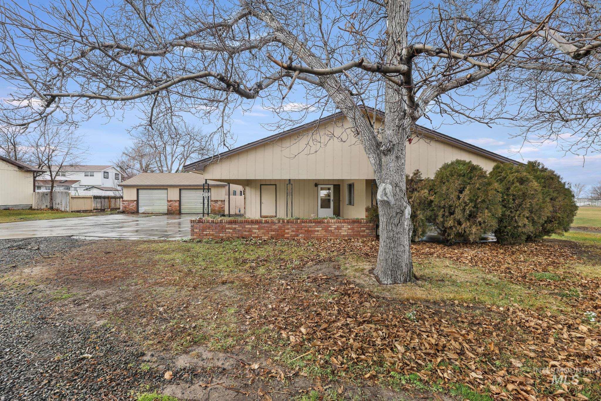 View of front facade featuring brick siding, driveway, a garage, and a porch