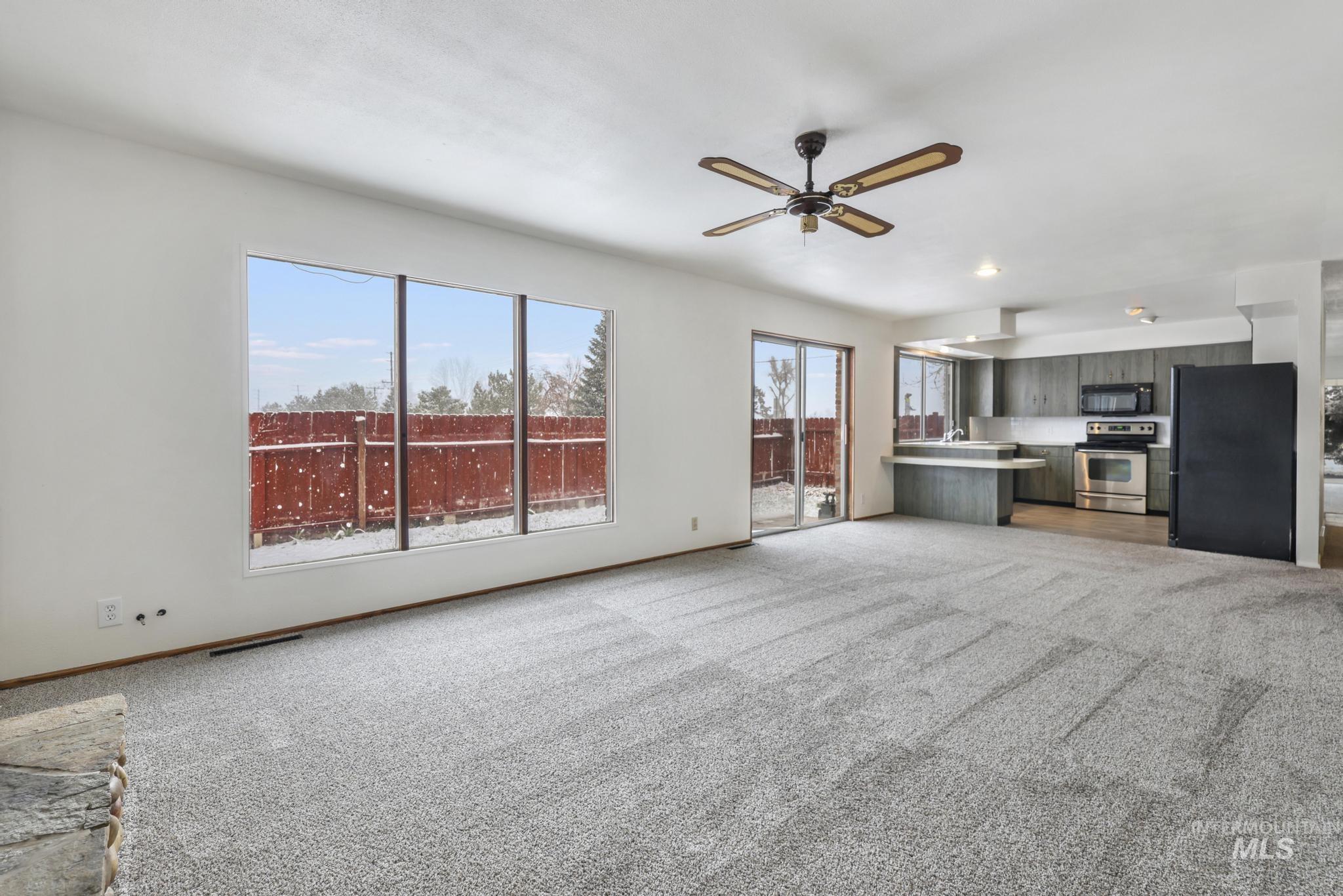 409 Clear Lakes Road Buhl, ID 83316 - Photo 11 of 43 Unfurnished living room featuring light colored carpet and a ceiling fan