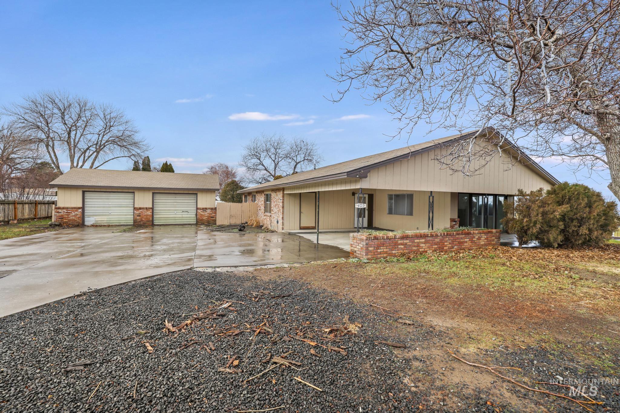409 Clear Lakes Road Buhl, ID 83316 - Photo 2 of 43 View of front of home with an outbuilding, a porch, brick siding, concrete driveway, and a garage