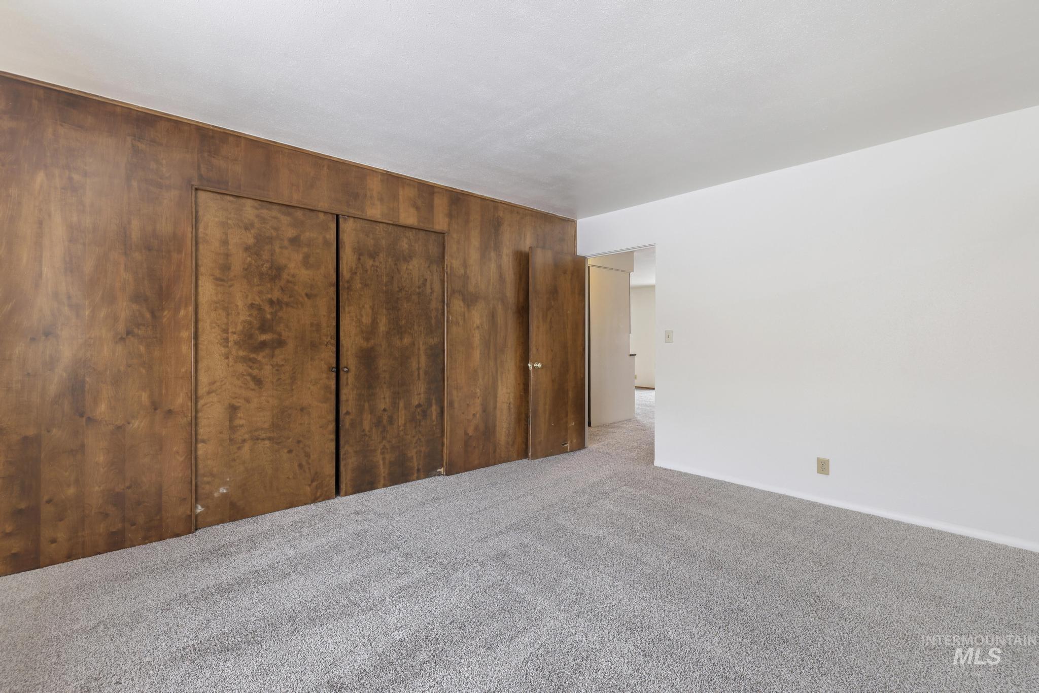 409 Clear Lakes Road Buhl, ID 83316 - Photo 23 of 43 Unfurnished bedroom with carpet flooring, a closet, and wood walls