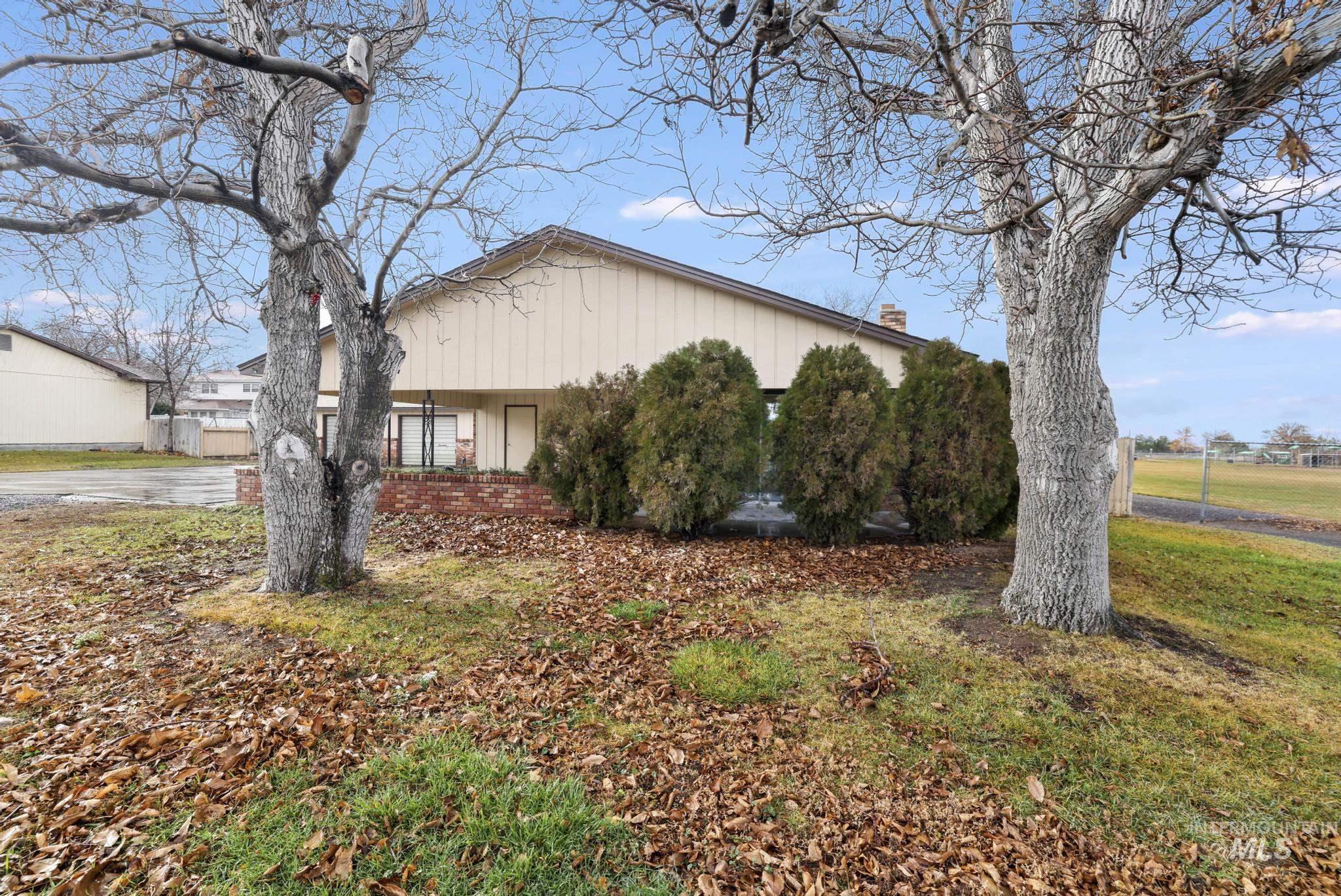 409 Clear Lakes Road Buhl, ID 83316 - Photo 3 of 43 View of home's exterior with brick siding, a chimney, and a lawn