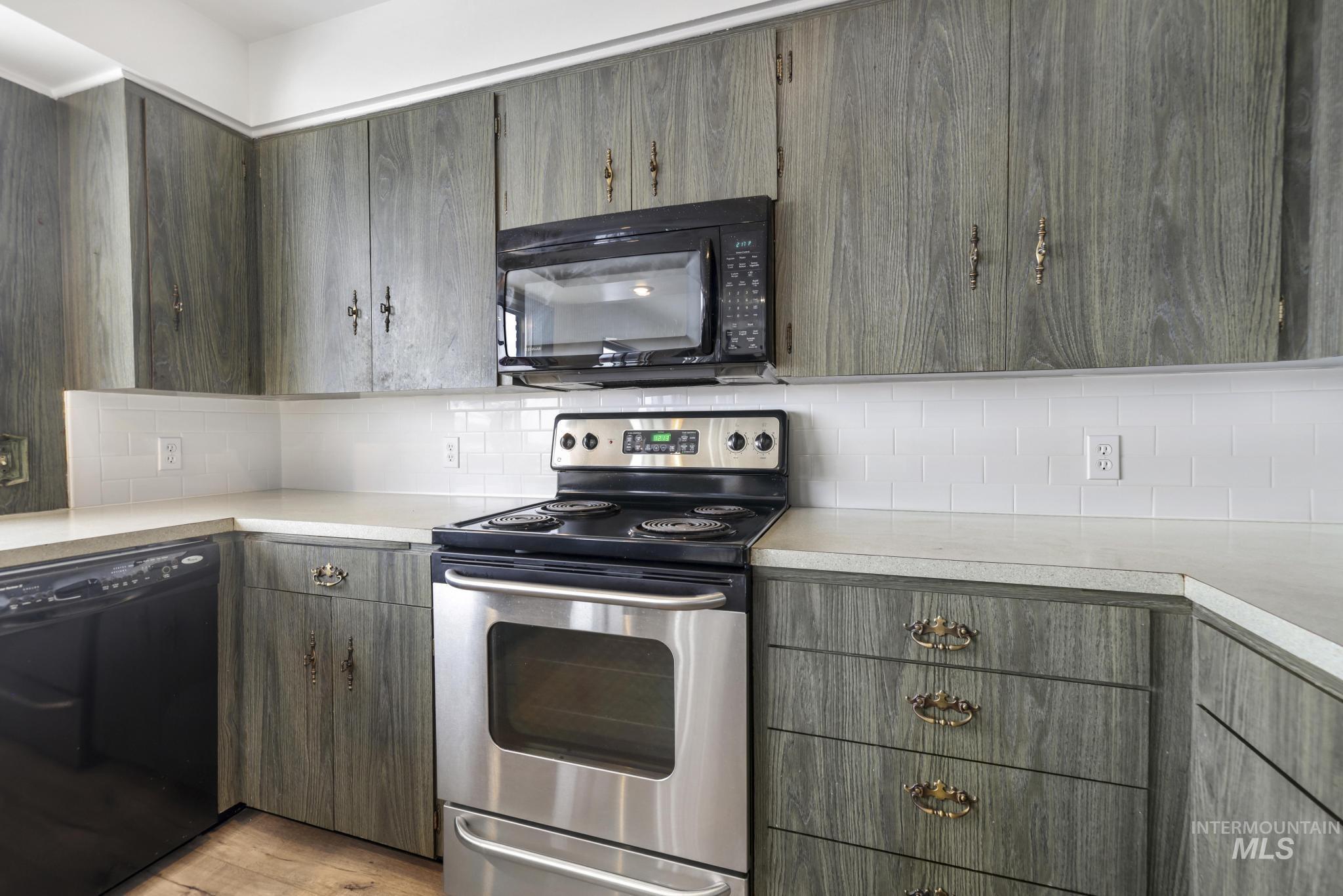 409 Clear Lakes Road Buhl, ID 83316 - Photo 8 of 43 Kitchen featuring black appliances, light countertops, decorative backsplash, and light wood-type flooring