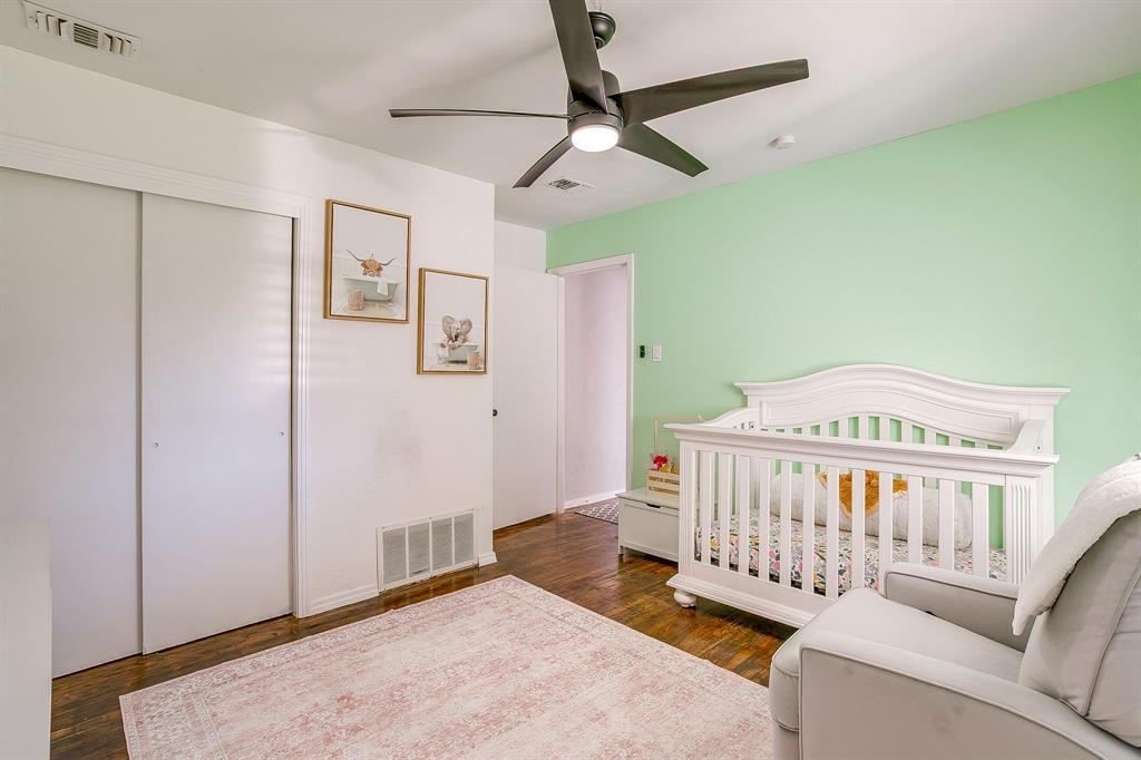137 Merritt Street Fort Worth, TX 76114 - Photo 16 of 30 a bedroom with a bed and wooden floor