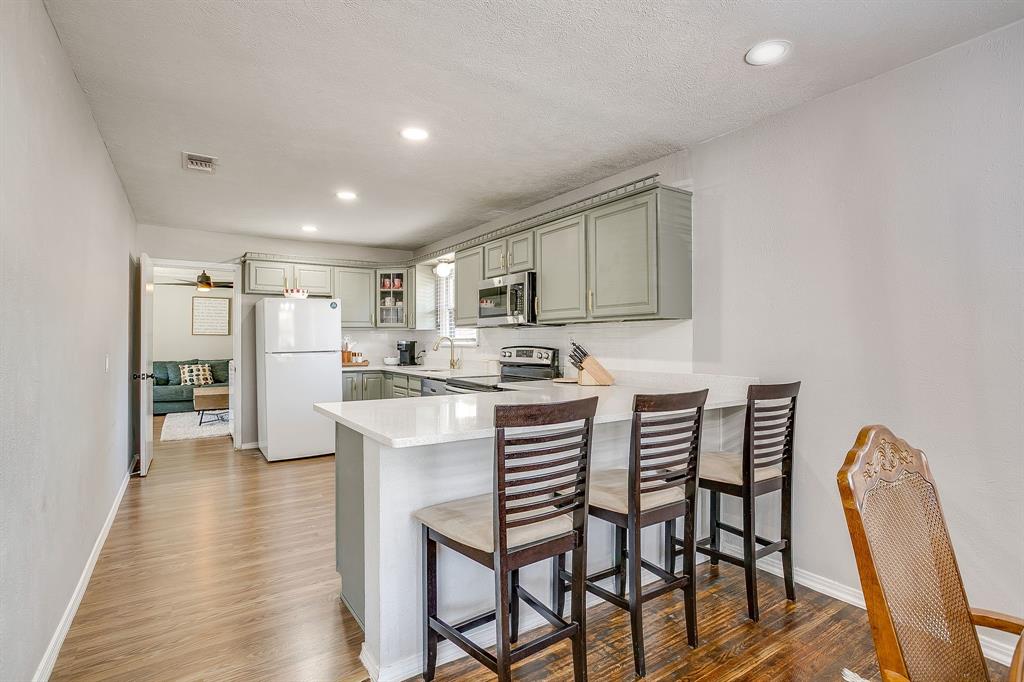 137 Merritt Street Fort Worth, TX 76114 - Photo 8 of 30 a kitchen with stainless steel appliances kitchen island granite countertop a dining table chairs and a refrigerator