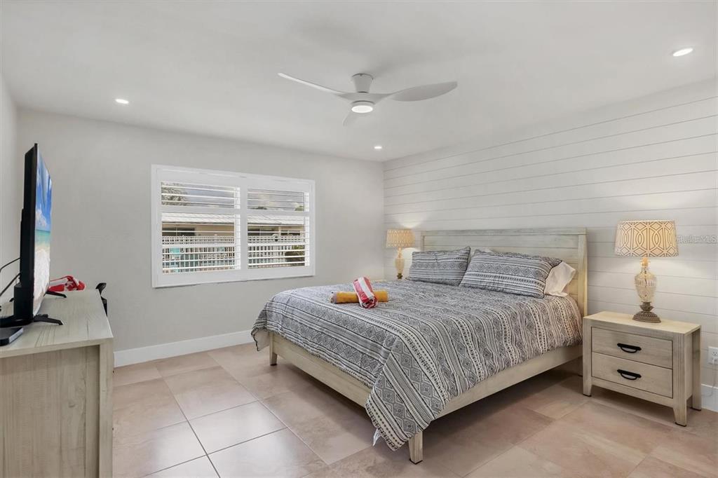 5830 Midnight Pass Road, Unit 54 Sarasota, FL 34242 - Photo 11 of 36 a bedroom with a bed and a flat screen tv