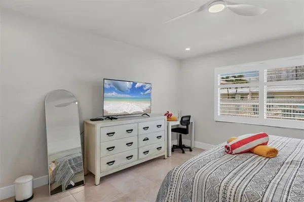 a bedroom with bed and a flat tv screen on dresser