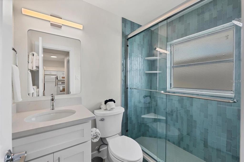 5830 Midnight Pass Road, Unit 54 Sarasota, FL 34242 - Photo 14 of 36 a bathroom with a sink toilet and shower