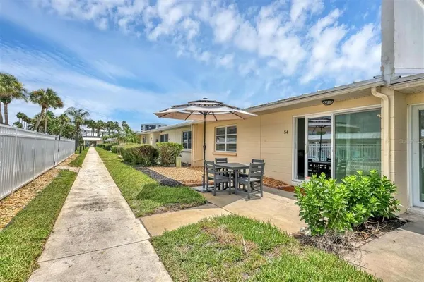 a front view of house with outdoor seating and green space