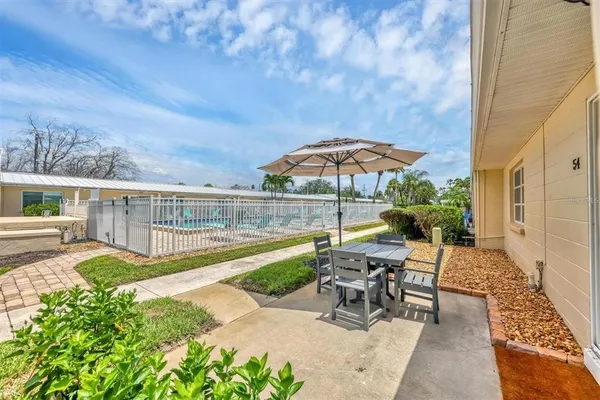a view of a patio with chairs under an umbrella