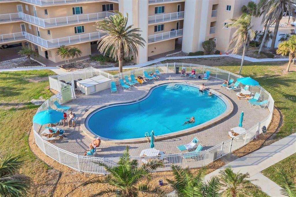 5830 Midnight Pass Road, Unit 54 Sarasota, FL 34242 - Photo 22 of 36 a view of a swimming pool with an outdoor seating