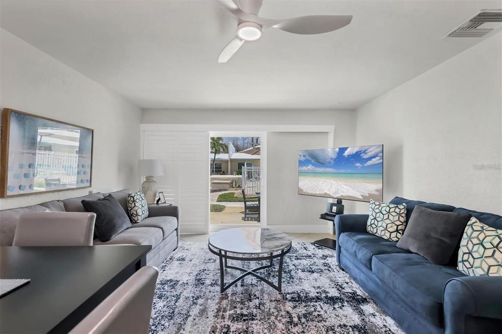 5830 Midnight Pass Road, Unit 54 Sarasota, FL 34242 - Photo 5 of 36 a living room with furniture and a wooden floor