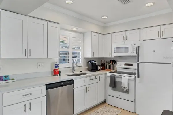 a kitchen with cabinets appliances a sink and a counter top space