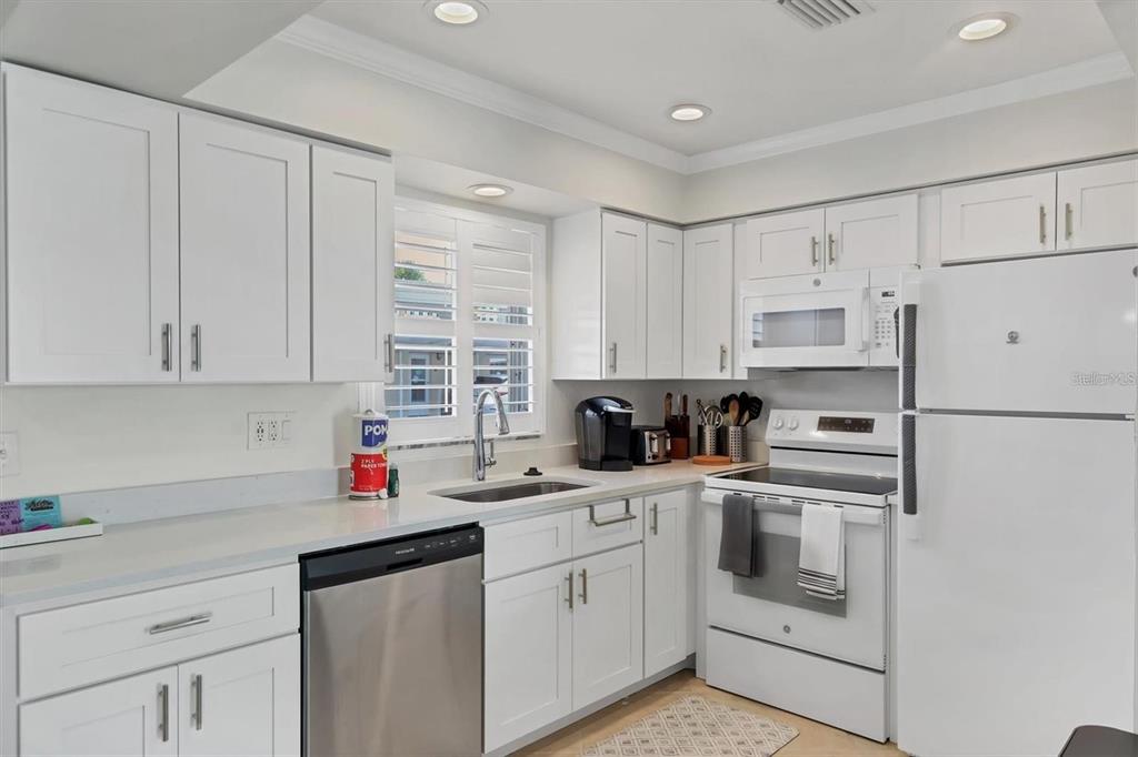 5830 Midnight Pass Road, Unit 54 Sarasota, FL 34242 - Photo 8 of 36 a kitchen with cabinets appliances a sink and a counter top space