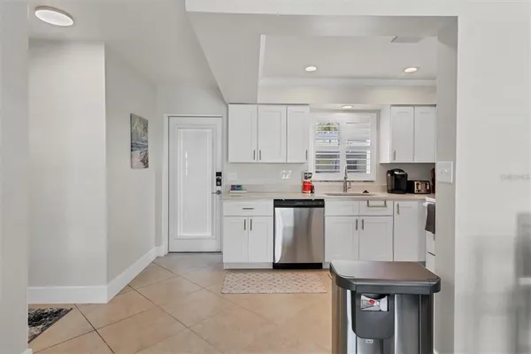 a kitchen with white cabinets and sink