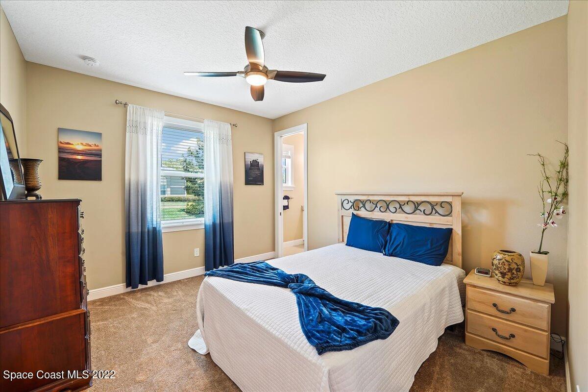 1360 Corey Road Malabar, FL 32950 - Photo 17 of 48 a bedroom with a large bed and a chandelier