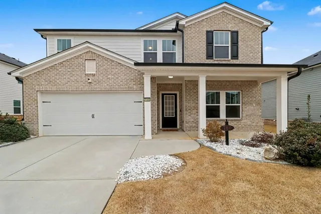 a front view of a house with a yard and garage