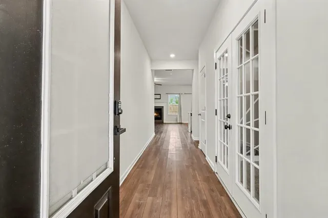 a view of a hallway with wooden floor and staircase