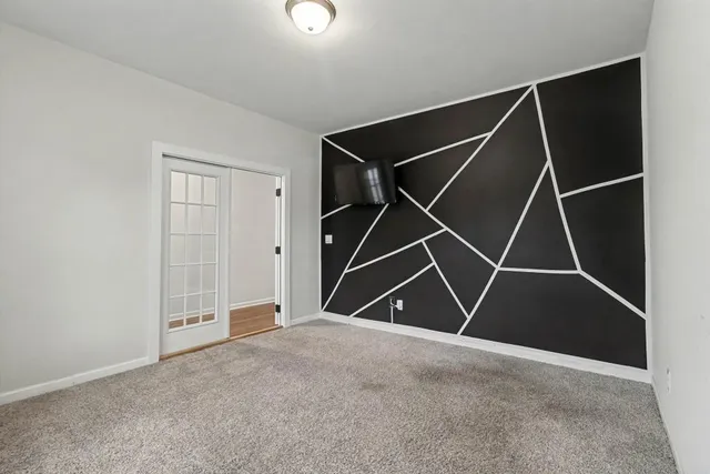 a view of an empty room with wooden floor fireplace and a window