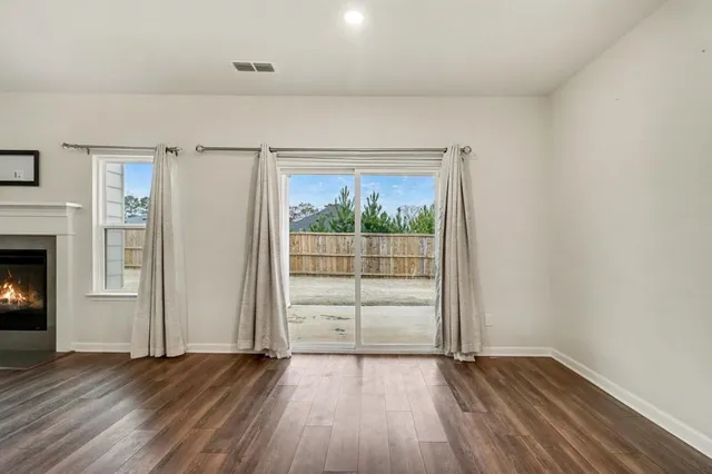 a view of a kitchen with a stove fridge and wooden floor