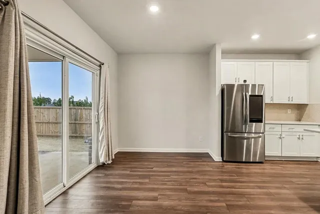 a kitchen with stainless steel appliances granite countertop a refrigerator sink and white cabinets