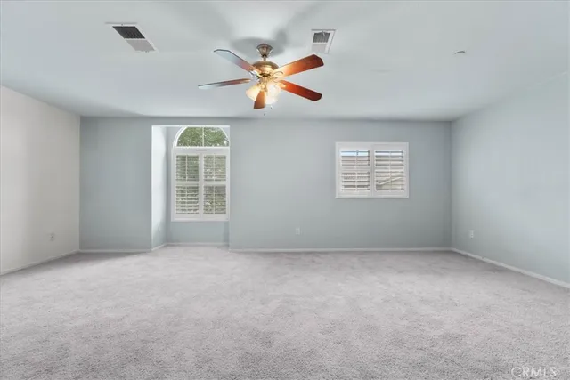a view of an empty room with a ceiling fan
