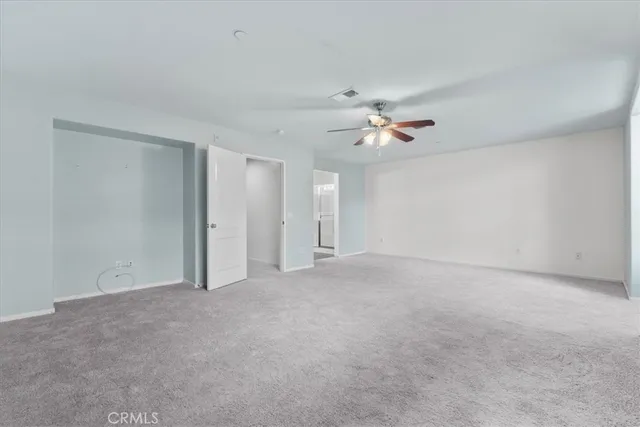 a view of an empty room with a ceiling fan