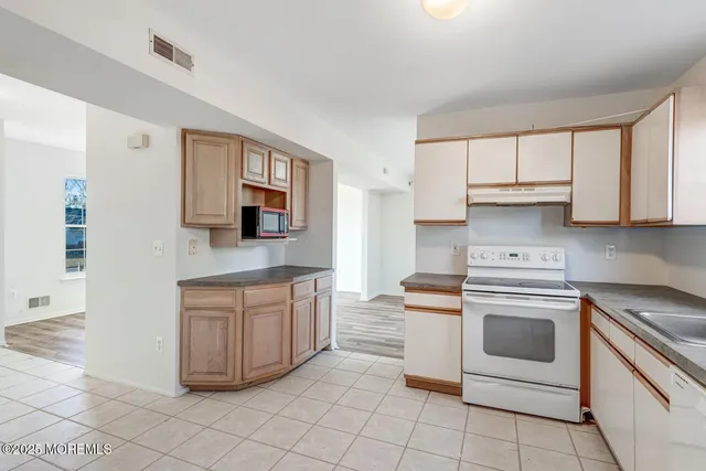 a kitchen with stainless steel appliances granite countertop a stove a sink and a microwave
