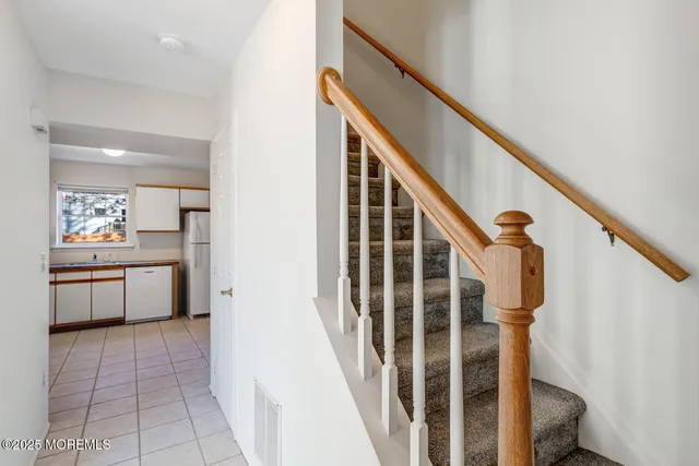 a view of a hallway with kitchen and entryway