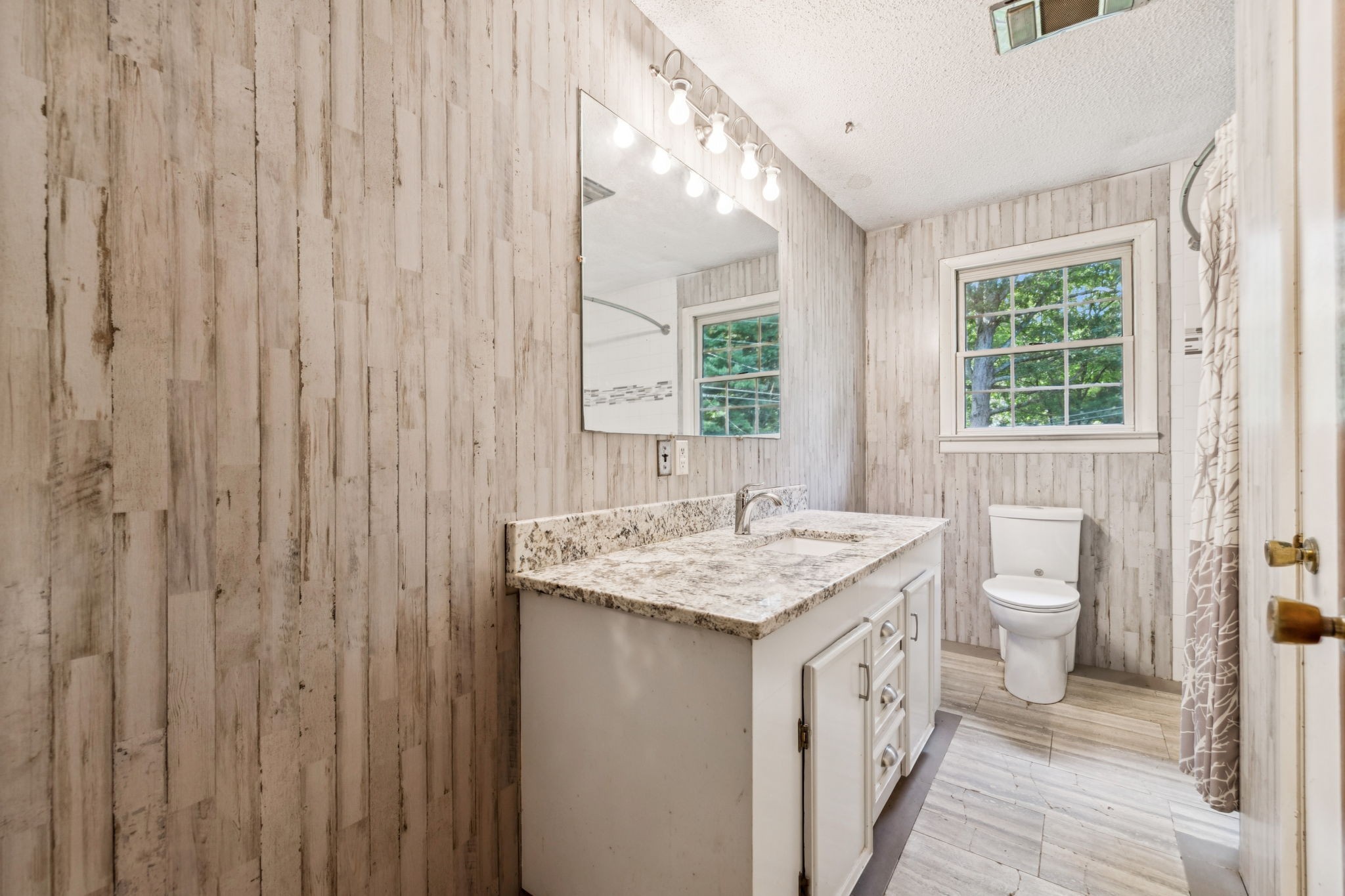 588 Sweeton Hill Road Coalmont, TN 37313 - Photo 15 of 51 a bathroom with a granite countertop sink a toilet and a window