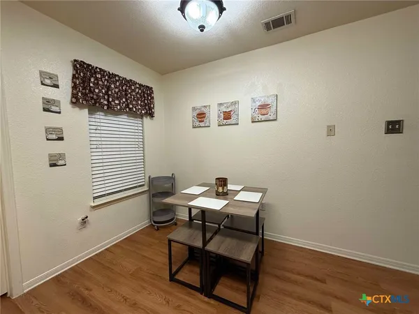 a view of a workspace with furniture and wooden floor