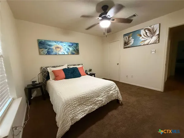 a bedroom with a large bed and a chandelier