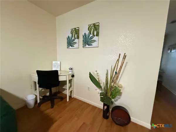 a view of a workspace with furniture and a potted plant