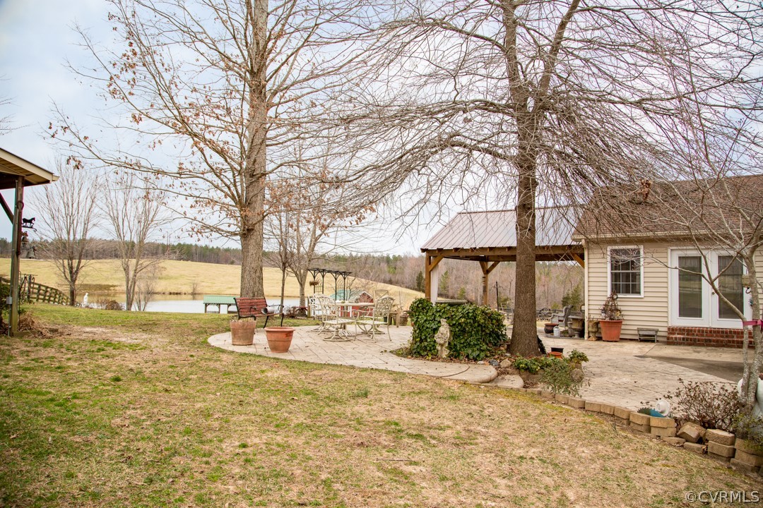 5584 The Falls Road Crewe, VA 23930 - Photo 29 of 29 a backyard of a house with table and chairs under an umbrella