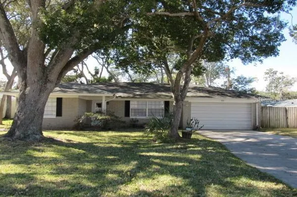 a view of a yard in front of a house with large tree