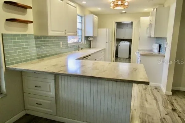 a kitchen with stainless steel appliances wooden floor and a sink