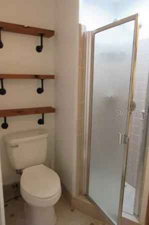 a bathroom with a toilet and a shower
