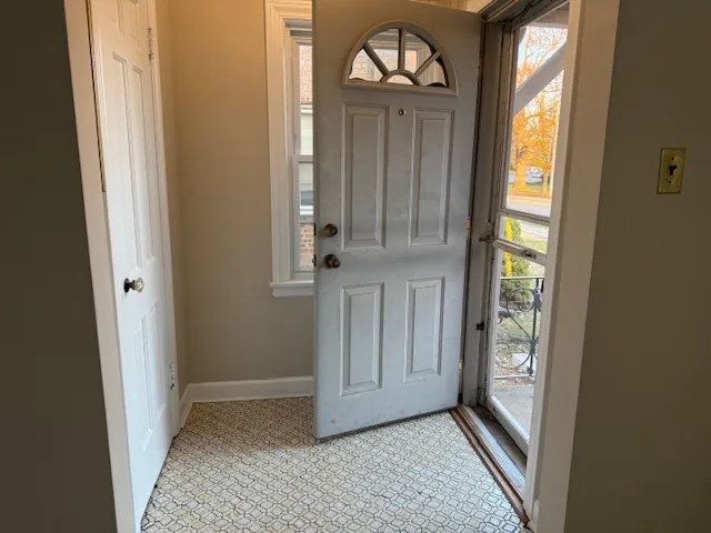 a view of a hallway with wooden floor and a door