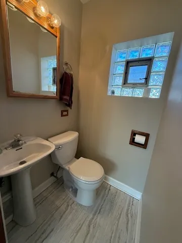 a bathroom with a toilet a sink and mirror