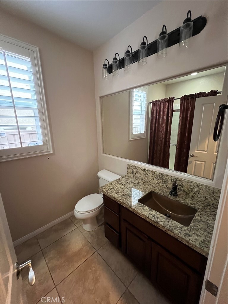 35429 Saddle Hill Road Lake Elsinore, CA 92532 - Photo 16 of 27 a bathroom with a granite countertop sink a mirror and a toilet
